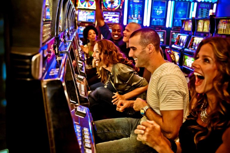 Парни и девушки навеселе отрываются за игровыми автоматами в казино