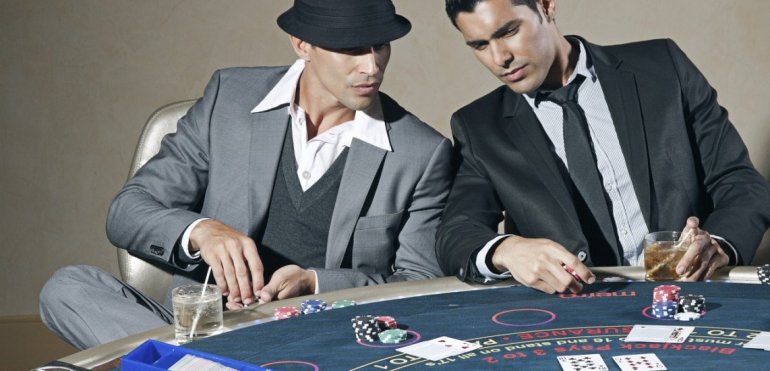 Двое интеллигентно одетых мужчин за игрой в блэкджек
