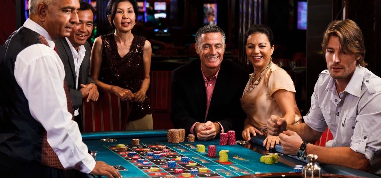 Азиаты и европейцы хорошо проводят время за игрой в рулетку в престижном казино