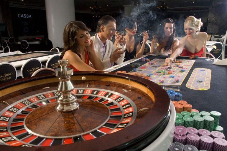 Компания красиво одетых молодых людей за игрой в рулетку в престижном казино