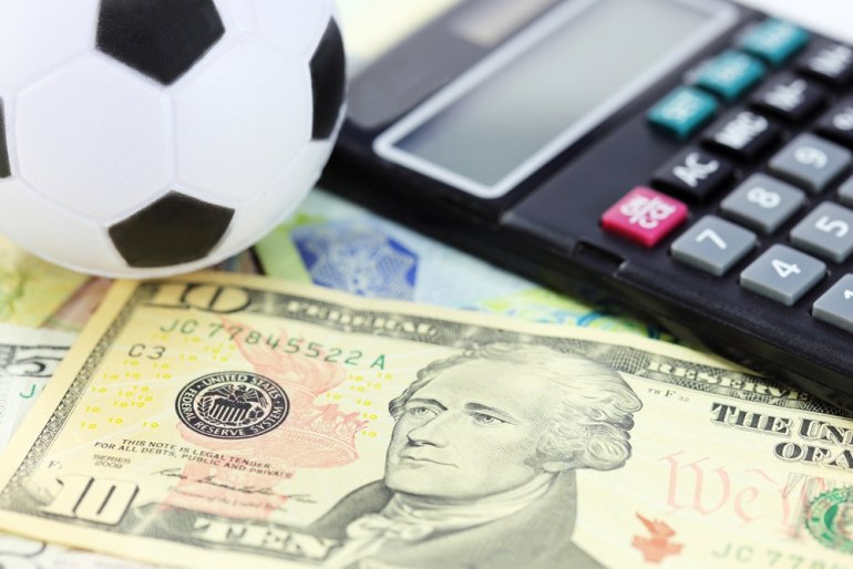 Футбольный мяч, долларовые купюры и калькулятор